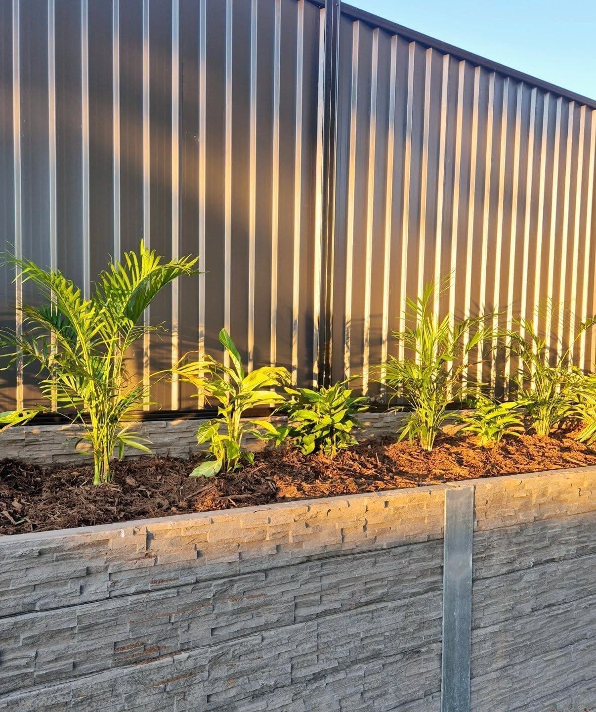 A finished concrete sleeper retaining wall in Logan Village