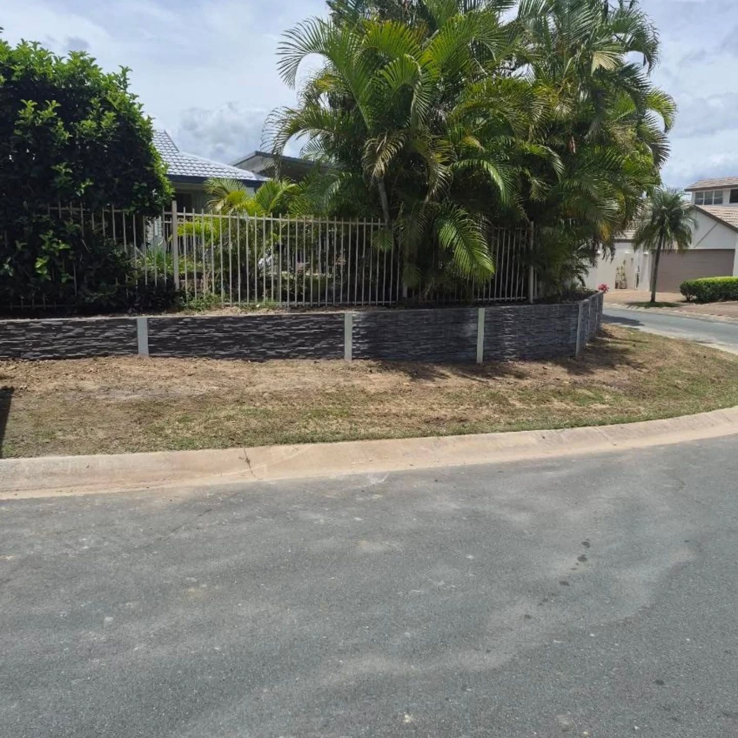 A finished concrete sleeper retaining wall in Coomera