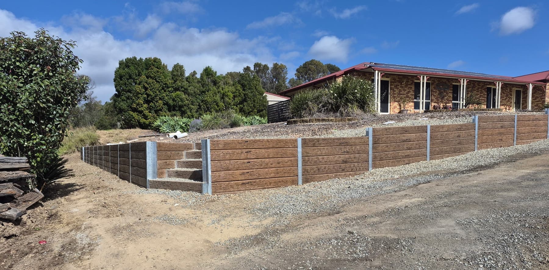 Timber look concrete sleepers along an acreage boundary, with steps